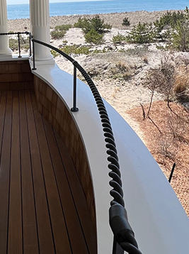 2 strand rope metal railing installed on curved exterior balcony