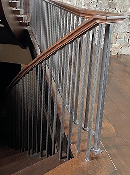 Aluminum stair spindles installed on curved interior staircase