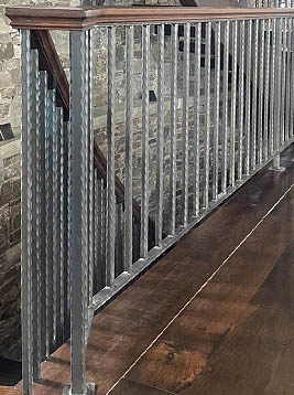 Antique newel posts with textured metal finish in balcony railing