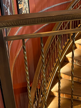 Brass balusters installed on curved interior stair railing
