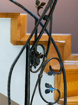 Custom newel posts with decorative wrought iron scroll design