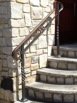 Exterior wrought iron balusters installed on stone stair railing