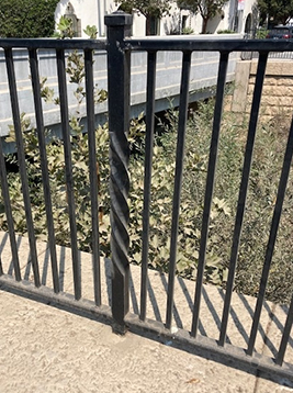 Fence spindles installed on exterior metal fence panel