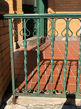 Iron deck spindles installed on exterior brick porch railing