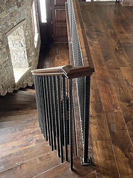 Iron staircase balusters installed on interior wood stair railing