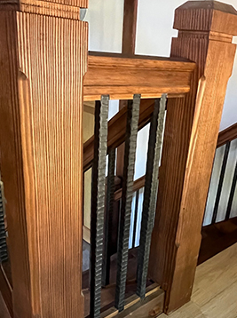 Metal stair balusters installed on traditional wood staircase