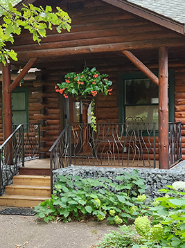 Porch spindles installed on rustic exterior log cabin porch