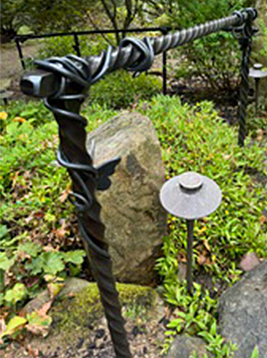 Textured newel posts with decorative iron detail in garden railing