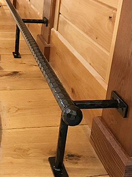 Textured round bar installed as horizontal stair railing support