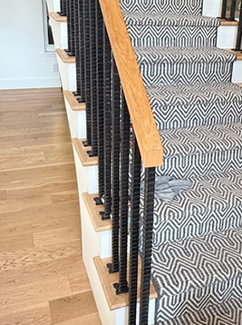 Wrought iron balusters installed on interior wood staircase