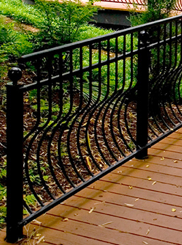 Metal railing with curved wavy balusters detail showing installed decorative spindles in outdoor deck railing system