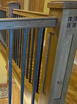 Metal stair railing with square balusters detail showing installed decorative spindles in interior staircase system