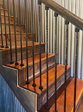 Square iron balusters installed on residential wood staircase