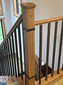 Metal stair handrail with vertical balusters detail showing installed decorative spindles in interior staircase system