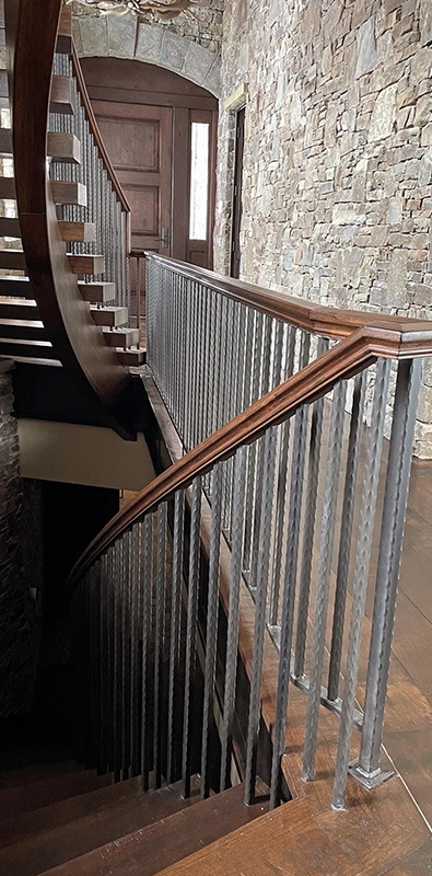 Aluminum stair spindles installed on curved interior staircase