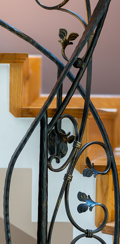 Custom newel posts with decorative wrought iron scroll design