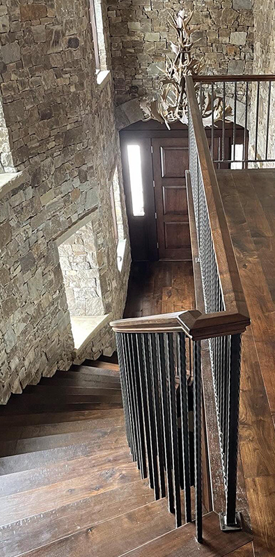 Iron staircase balusters installed on interior wood stair railing