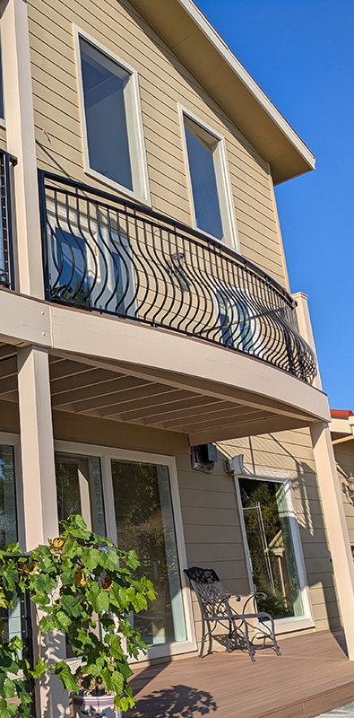 Metal deck spindles installed on curved exterior balcony railing