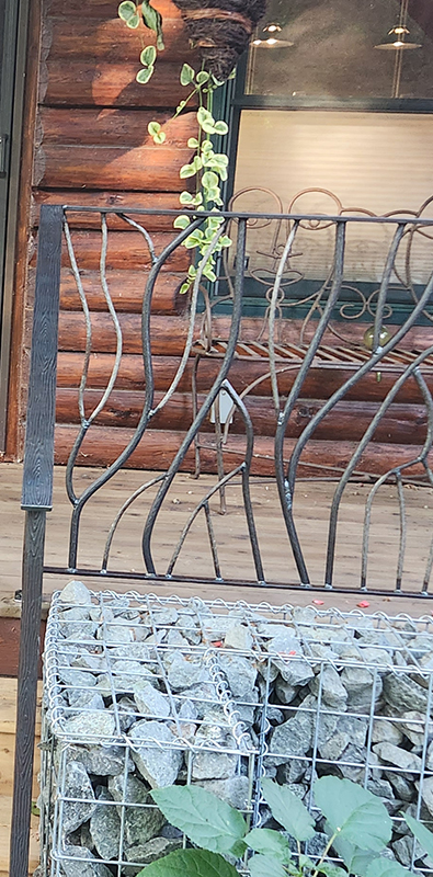 Porch railing balusters installed on rustic exterior log cabin porch