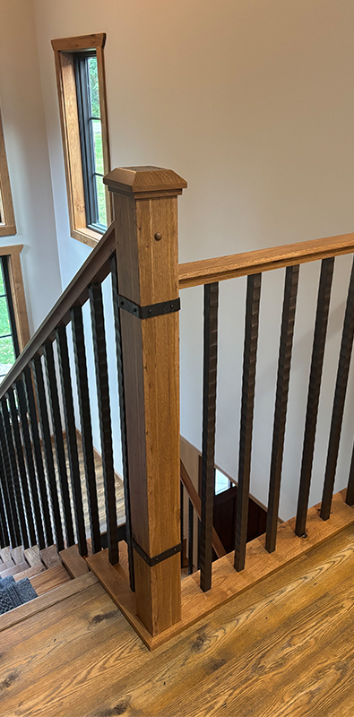 Metal stair handrail with vertical balusters detail showing installed decorative spindles in interior staircase system